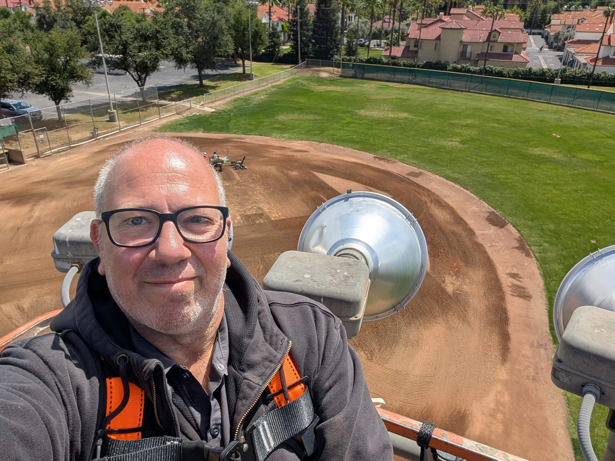 Reliant Electrical crew in boom lift servicing stadium light pole at Bethany Church baseball field
