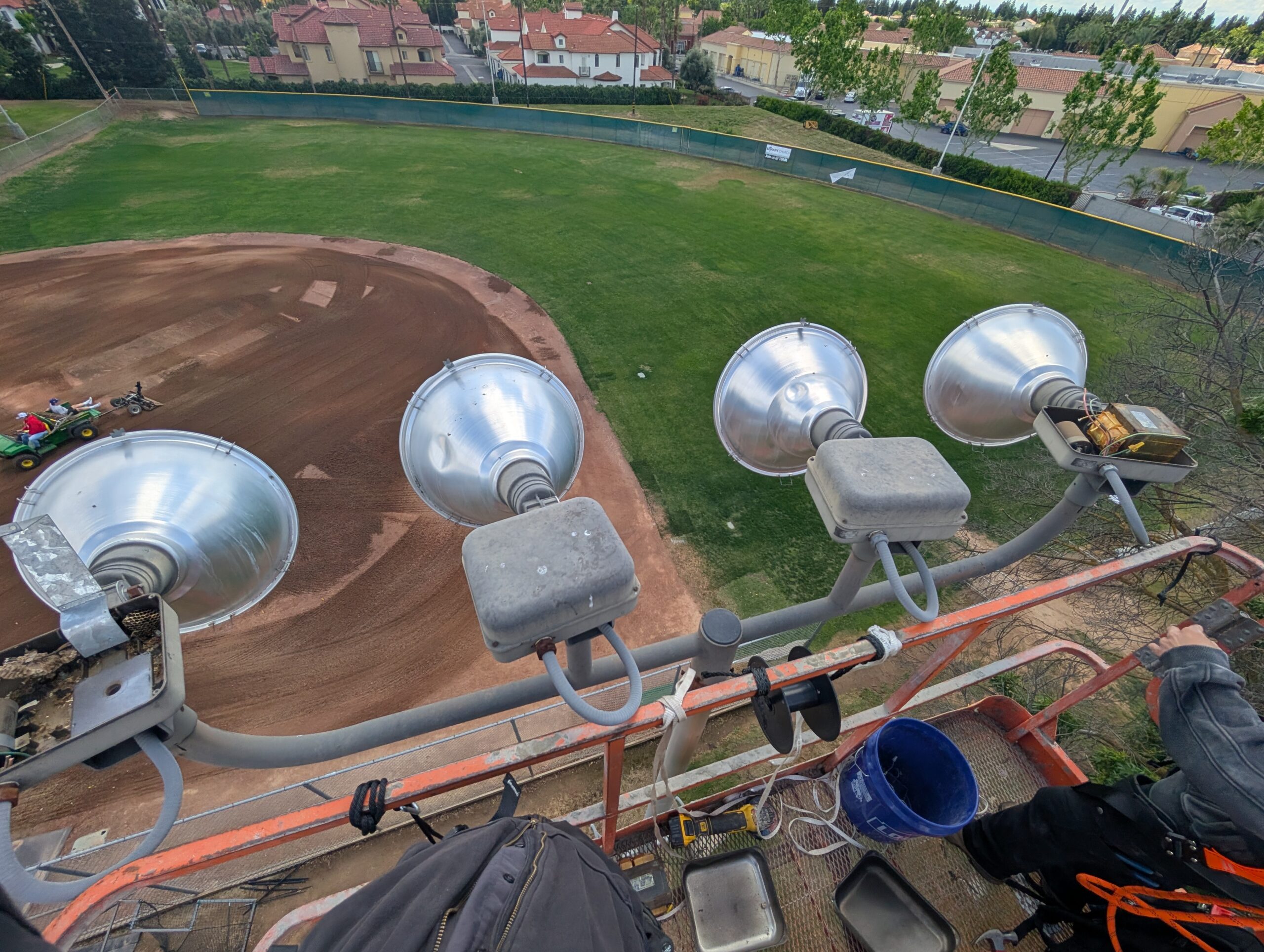 Electrician working on light fixture from articulating boom lift