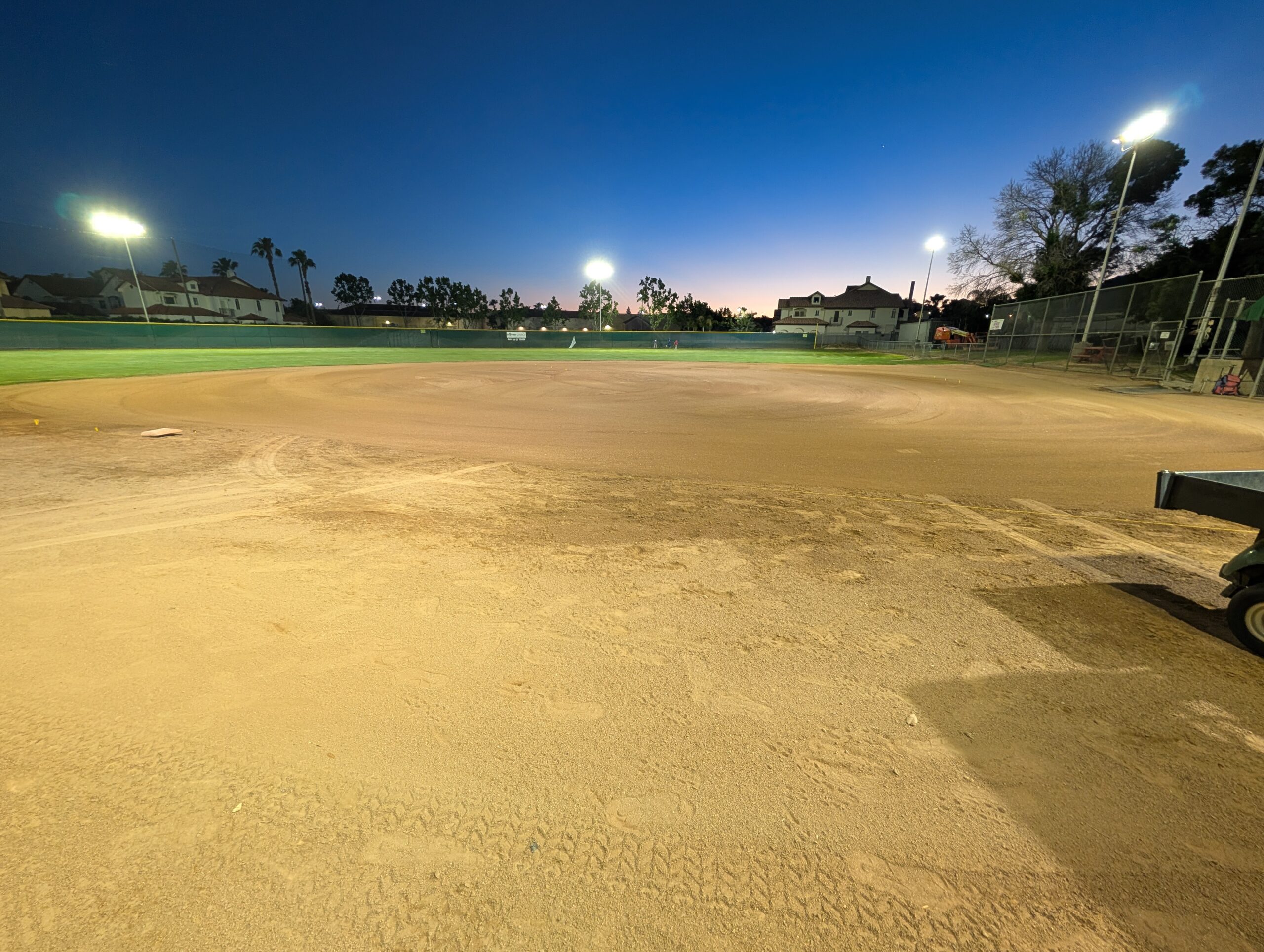 Wide view of lit baseball field at night with new LED lighting by Reliant Electrical